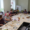 Wspólne biesiadowanie przy stole w Klubie Seniora